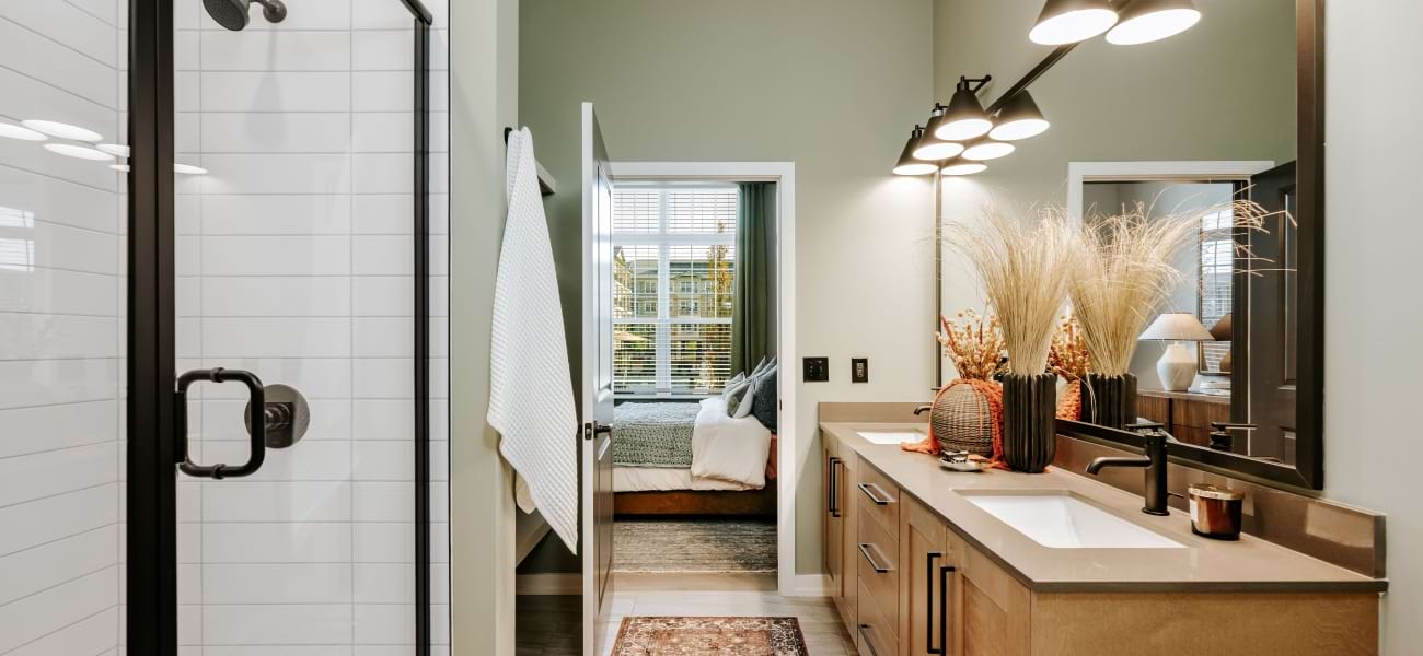Spacious bathroom with dual vanity, framed mirror, and glass framed walk-in shower with tile Spacious bathroom with dual vanity, framed mirror, and glass framed walk-in shower with tile