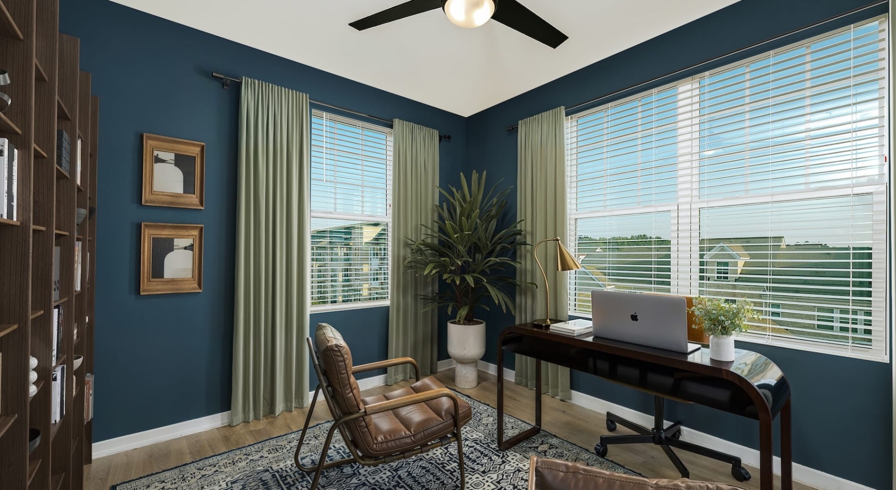 study area in a painted room with a desk, chairs  and city views through large windows